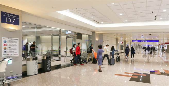中央流行疫情指挥中心指挥官王必胜28日宣布，从明年1月1日起到31日为期一个月，对来自中国四个航点的入境乘客进行唾液PCR检验，并进行0＋7自主防疫，初步是规划在第二航厦D7到D9的入境长廊专案专用，将航班集中在D7、D8、D9这3个候机室处理，相关区域为中国航班专用，其他的旅客不会过去。图为桃园机场入境旅客。（陈麒全摄）