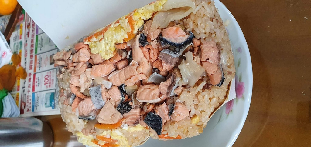 一名網友表示，在北市萬華買一份鮭魚炒飯，炒飯堆得跟小山，塞爆紙盒蓋不起來，滿滿的鮭魚肉塊，讓網友暴動。（圖／翻攝自爆廢公社二館）