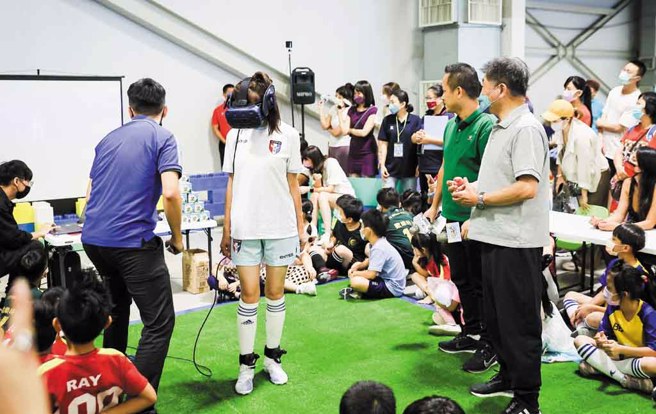 ▲中华民国迷你足球协会推广大使、台北市议员许淑华穿戴VR设备模拟各个踢球动作相当俐落。(图／中华民国迷你足球协会提供)

