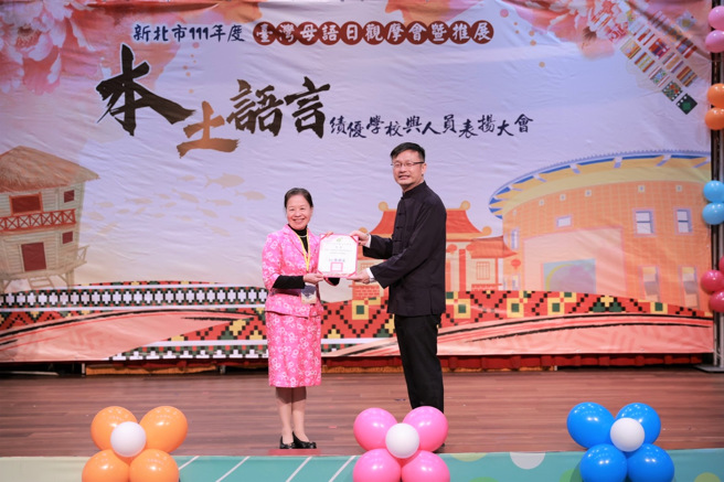 教育局长张明文颁发予荣获本土语指导员访视绩优教学人员的客语教学支援工作人员徐凤英老师。(照片/新北教育局提供)