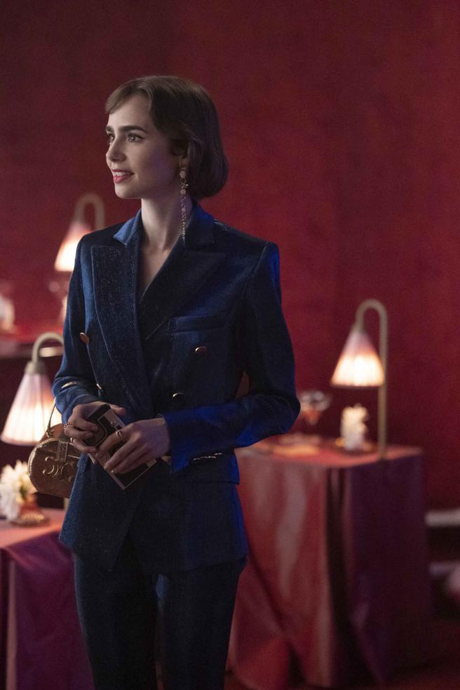 艾蜜莉 以Balmain蓝色天鹅绒西装外套搭配Celine包款，展现华贵气质。（Netflix提供）