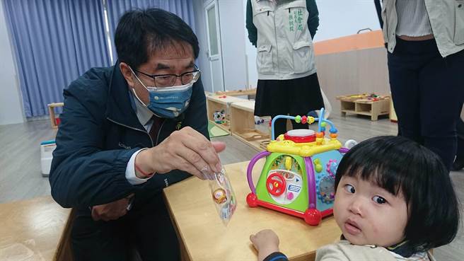 台南市长黄伟哲拿糖果与公托家园内的幼儿互动。（程炳璋摄）