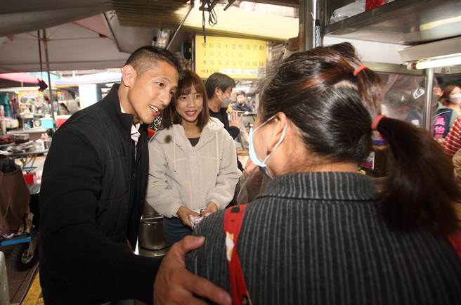 民進黨台北市第三選區立委補選候選人吳怡農（左）與太太顏采薇（左二）30日首度合體，一同到晴光市場掃街拜票，過程中，親切地嶄露笑容，與民眾噓寒問暖。（張鎧乙攝）