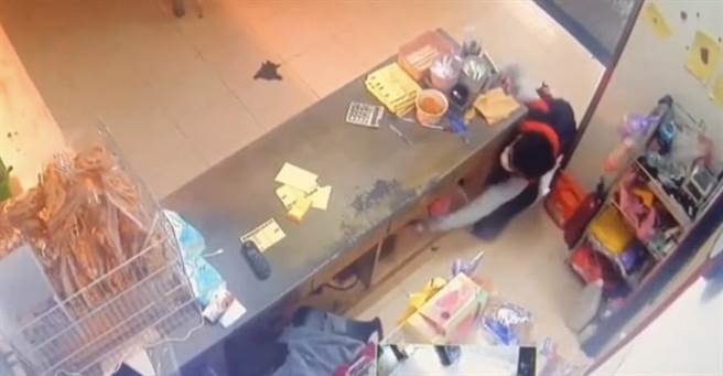 高雄一名穿背心的男贼伸手进柜台底下偷包。（翻摄照片／高雄洪靖宜传真）