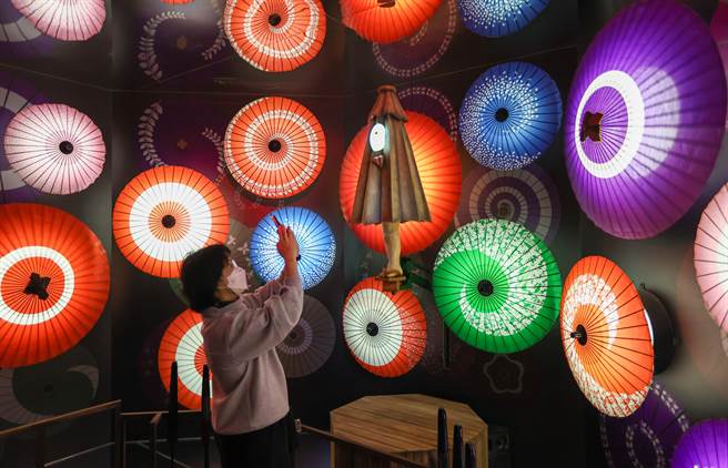 日本水木工作室特地將全新企劃「鬼太郎妖怪100物語」搬來台灣，海外第一站選擇台北華山展出，展場內展示可愛又有魅力妖怪傘妖，民眾用手機拍照留念。（羅永銘攝）