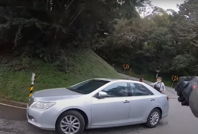 有骑士在山路的急转弯道上，竟然惊见有辆汽车竟停在转弯处，他赶紧提醒驾驶很危险，却被回呛「这白线欸」。（翻摄自YouTube频道「WoWtchout - 地图型行车影像分享平台」）