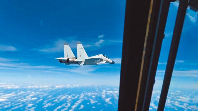 美军印太司令部公布中共1架歼-11战斗机，21日在南海上空靠近美军RC-135侦察机飞行画面。（路透）