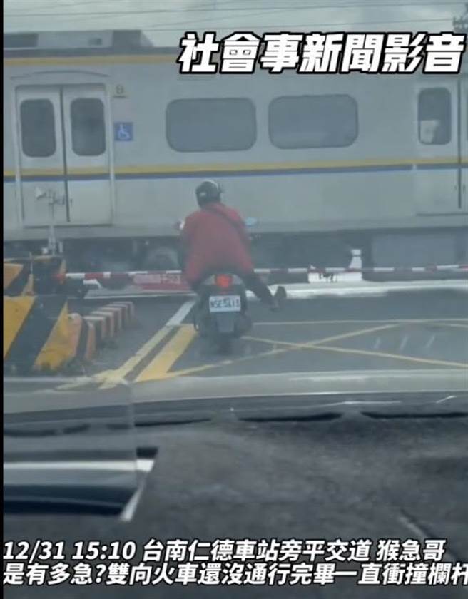 穿红外套的机车男骑士昨天下午行经台南仁德车站旁平交道前，刻意猛催油门衝撞遮断杆。（摘自爆料公社脸书）