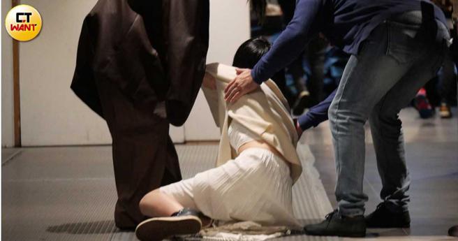也許是不勝酒力，美麗妄娜腿軟跌坐在地上，兩個朋友連忙伸手扶她。（圖／本刊攝影組）