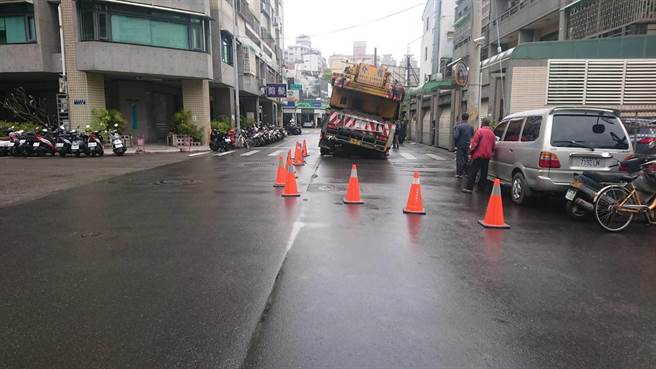 台中市南屯區三厝街路面塌陷，重達80噸的吊車卡在路中央，動彈不得。(民眾提供)