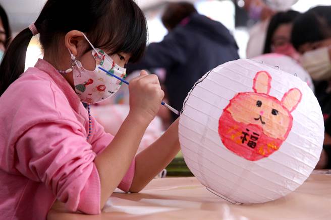 新北市新庄区公所迎新年庆元宵系列活动，首波主打的「彩绘灯笼·幸福兔U」活动2日热闹登场，小朋友专注地在空白的灯笼上，创作属于自己的兔年提灯。（黄世麒摄）