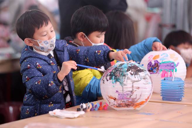 新北市新庄区公所迎新年庆元宵系列活动，首波主打的「彩绘灯笼·幸福兔U」活动2日热闹登场，小朋友们专注地在空白的灯笼上创作。（黄世麒摄）