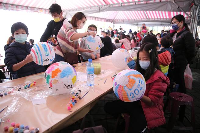 新北市新庄区公所迎新年庆元宵系列活动，首波主打的「彩绘灯笼·幸福兔U」活动2日热闹登场，小朋友们专注地在空白的灯笼上创作。（黄世麒摄）
