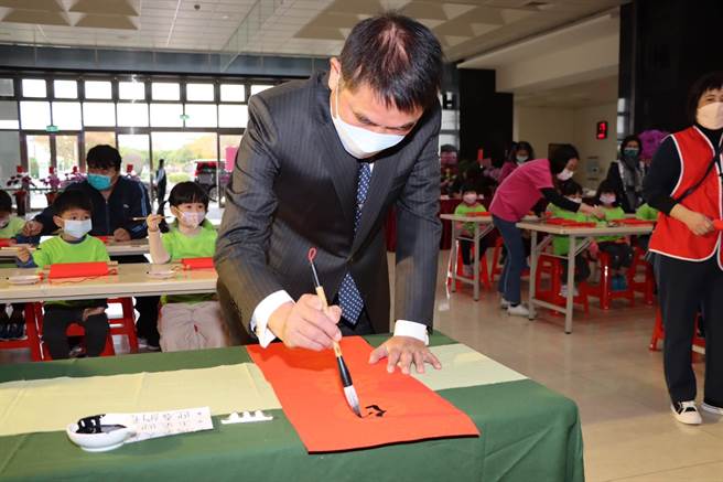 苗栗县长锺东锦与幼儿园小朋友在卷轴以书法写下新年祝福。（李京升摄）