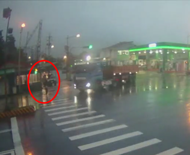 宜兰县冬山乡3日晚间发生砂石车撞上行人的车祸，红圈处可见女学生趁着行人号志灯为绿灯，准备快步穿越马路。（翻摄照片）