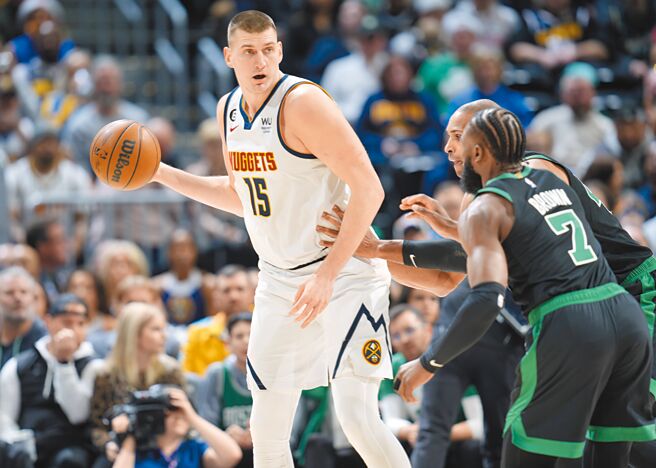 虽被荷福德用手撑住腰部，约基奇仍边运球边找传球对象。（美联社）