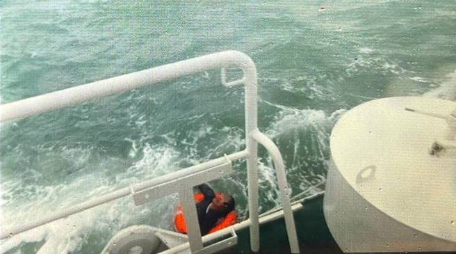 東引海域貨輪沉沒 5船員跳海1獲救，1名船員待在海面浮起的貨櫃上被海巡警艇救起，另外4人失蹤。(戴志揚翻攝)