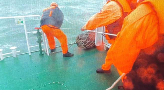 東引海域貨輪沉沒 5船員跳海1獲救，1名船員待在海面浮起的貨櫃上被海巡警艇救起，另外4人失蹤。(戴志揚翻攝)