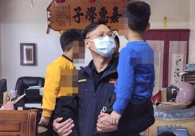 高雄市冈山警分局甲围所所长黄靖维关心两名孩童。（民眾提供／林瑞益高雄传真）