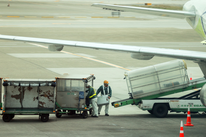 长荣航勤不满年终仅领1个月，元旦连假集体请假不出勤表达抗议。图为少数上班的长荣航勤人员在机坪作业情况。（陈麒全摄）