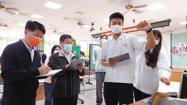 專題製作組評審黃順發校長(左一)、李恩銘校長(左二)研究櫥窗設計3D模型