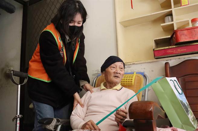 蔡衍明愛心基金會與南華大學師生針對3戶弱勢家庭送上5000元旺福紅包和餅乾等物資，學生志工還幫阿公按摩。（呂妍庭攝）