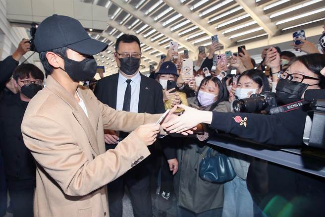 丁海寅（左）與接機粉絲握手致意。（范揚光攝）