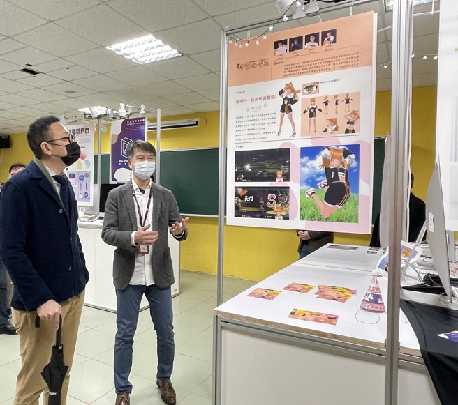 多媒体设计系提供设备及空间让同学展示专题作品，谢安执行长（左）仔细欣赏学生的作品。(照片/圣约翰科技大学提供)