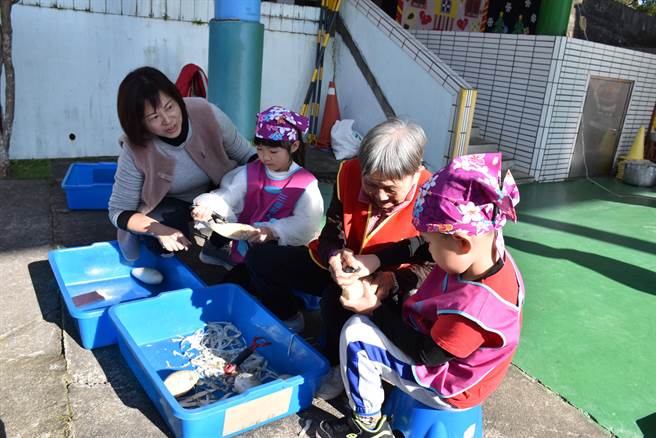 三义乡百岁人瑞陈阿婆手把手地教导小朋友做萝卜糕。（谢明俊摄）