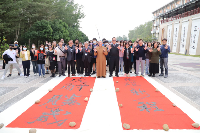 释慧开副校长与叶宗和院长、林辰璋副校长、林家仪理事长四位分成二组，在长400公分、宽200公分的大红纸上接龙书写「虎辞胜岁、兔跃新程」，当天还特别运用两台空拍机拍摄，记录开笔仪式气势磅礡的视觉效果。(照片/南华大学提供)