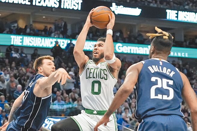 赛尔提克球星塔图（中）强攻篮下，独行侠射手东契奇（左）阻挡不及。（美联社）