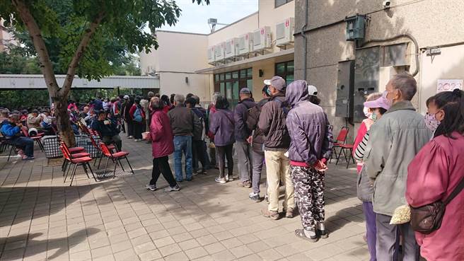 光武里活动中心赠春联活动有吃又有拿，现场赠送麵食吸引民眾大排长龙。（程炳璋摄）