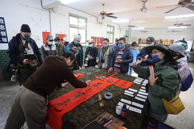 金門植物園邀請退役將軍鄭有諒（左1），以戰地標語為內容，現場揮毫寫出充滿軍事味的春聯。（圖／金門縣林務所提供）