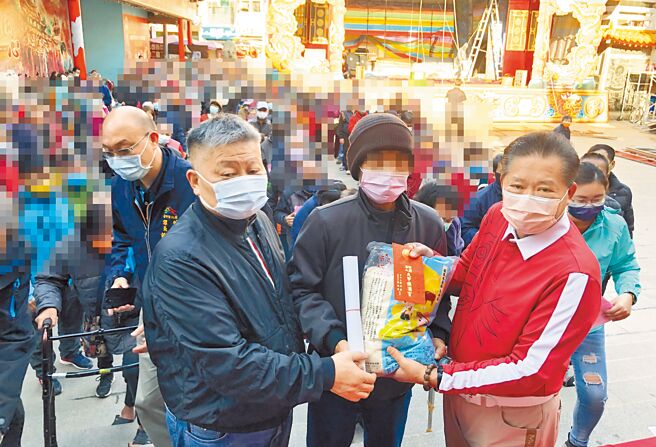 大甲镇澜宫昨天举办甲安埔冬令救济共1200户，由董事长顏清标（左）、副董事长郑铭坤（右），发放米及春联和1个小红包给民眾过年。（陈世宗摄）