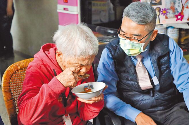 今年首份鸡汤，由县府秘书长邱黄肇崇（右）亲自送给家住屏东市的84岁康笑阿嬷（左）。（谢佳潾摄）