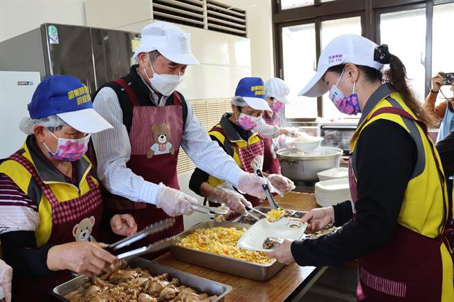 锺东锦也跟着志工帮长辈们打菜。（苗栗县政府提供／李京升苗栗传真）