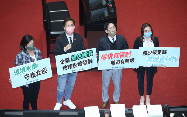 立法院10日院会三读通过「温室气体减量及管理法修正草案」，并更名为「气候变迁因应法」，民眾党立委陈琬惠（右起）、张其禄、邱臣远、吴欣盈拿着标语在议场内拍照留念。（姚志平摄）