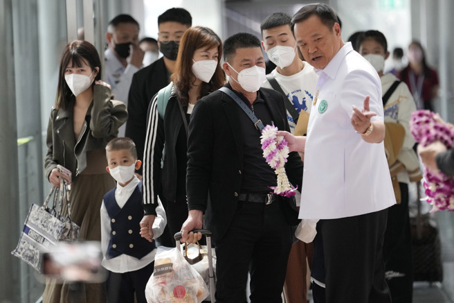 泰國副總理兼衛生部長阿努廷率領內閣成員，帶著鮮花禮物親自前往機場迎接解封後首批前往泰國旅遊的中國遊客。（圖／美聯社）