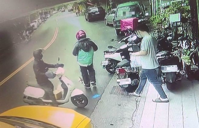 蔡姓外送员钱包不慎掉在地上，被后方的黑衣骑士见状捡走。（翻摄照片／林郁平台北传真）