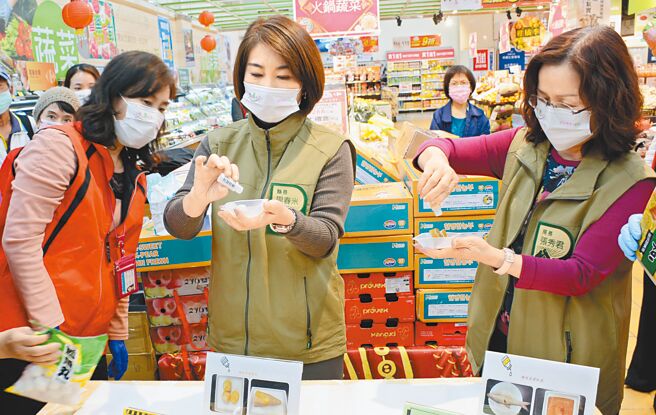 农历春节将至，屏东县长周春米（中）前进卖场视察，并使用简易试剂，观察食品是否符合规范。（林和生摄）