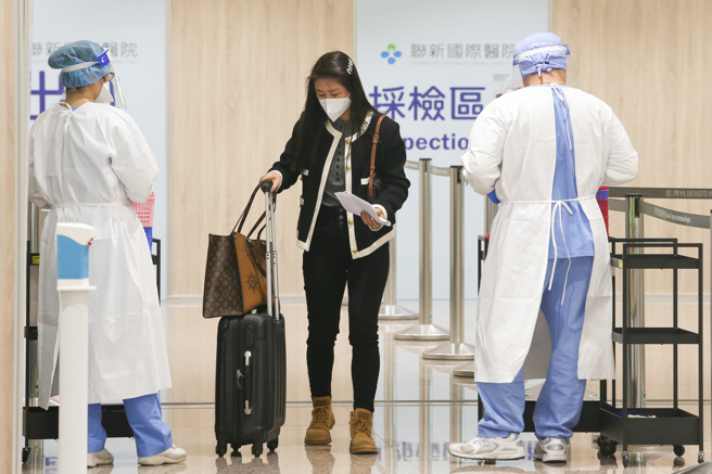 新冠疫情持續燒，入境旅客排隊入境唾液PCR採檢。（陳麒全攝）