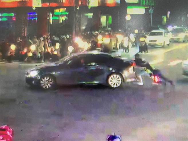 高雄女警高逸然在後方推車，協助駕駛將車輛脫困。（翻攝照片／崔正綱高雄傳真）