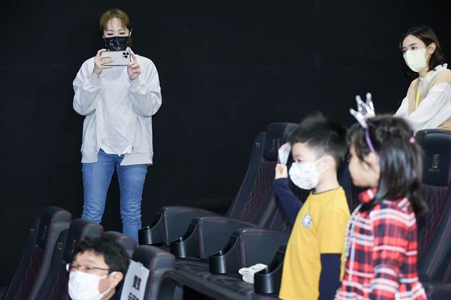 洪百榕拿起手机在一旁捕捉儿子看到巧虎后开心的模样。（罗永铭摄）