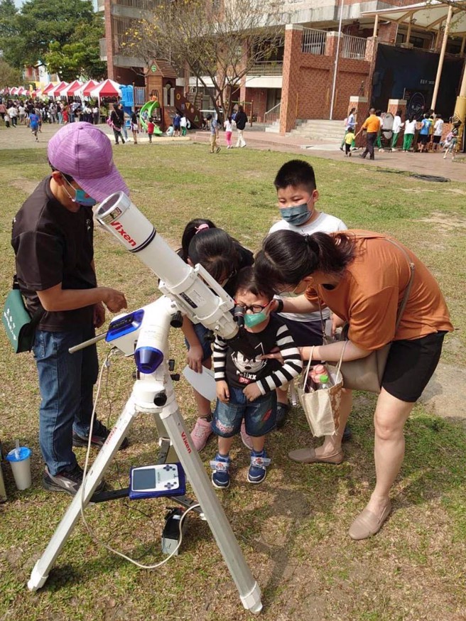 「路边天文」活动，2022年诸罗春分日，天文志工协助亲子利用天文望远镜观测太阳。(图／臺南市教育局)
