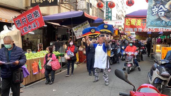 豐原派出所員警13日化身喜氣財神爺及警察大頭娃娃，踩街遊行至第一市場進行宣導。（警方提供）