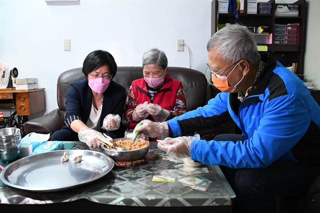 彰化县长王惠美于独居老奶奶一起包饺子，赠送关怀金。（吴敏菁摄）