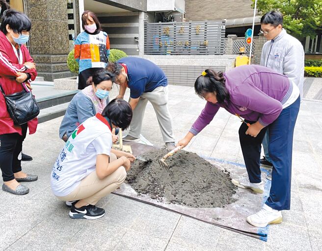 社区居民与信义房屋房仲一起翻土，种下花草。（信义房屋提供）
