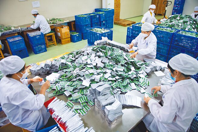 大陆防疫政策转弯后，确诊者暴增，导致农村药品短缺，许多地方近日发起「带药返乡」互助运动。图为大陆湖南一家药品工厂员工忙着包装药物。（新华社）
