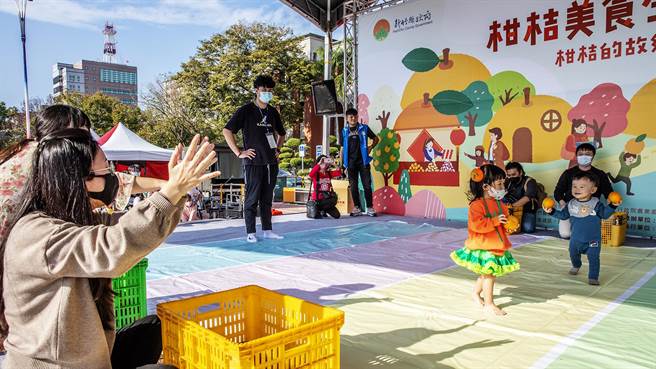 竹县柑桔美食生活节举办「宝宝抓柑桔计量赛」，1岁多幼儿拿了橘子跑错方向。（罗浚滨摄）