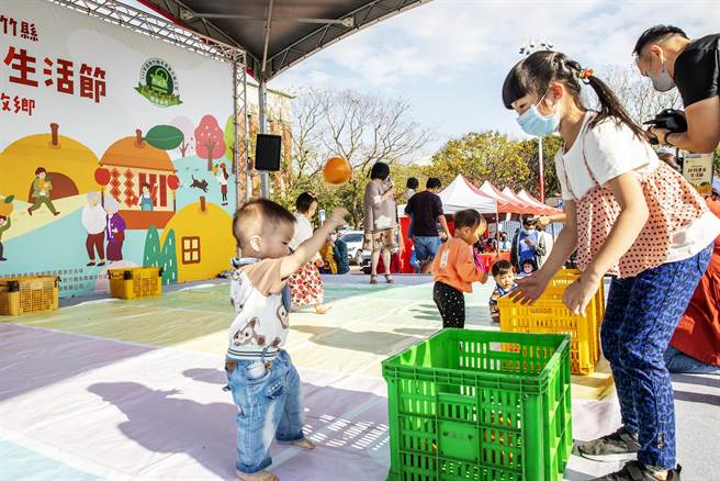 竹县柑桔美食生活节举办「宝宝抓柑桔计量赛」，1岁多幼儿把橘子当球丢。（罗浚滨摄）
